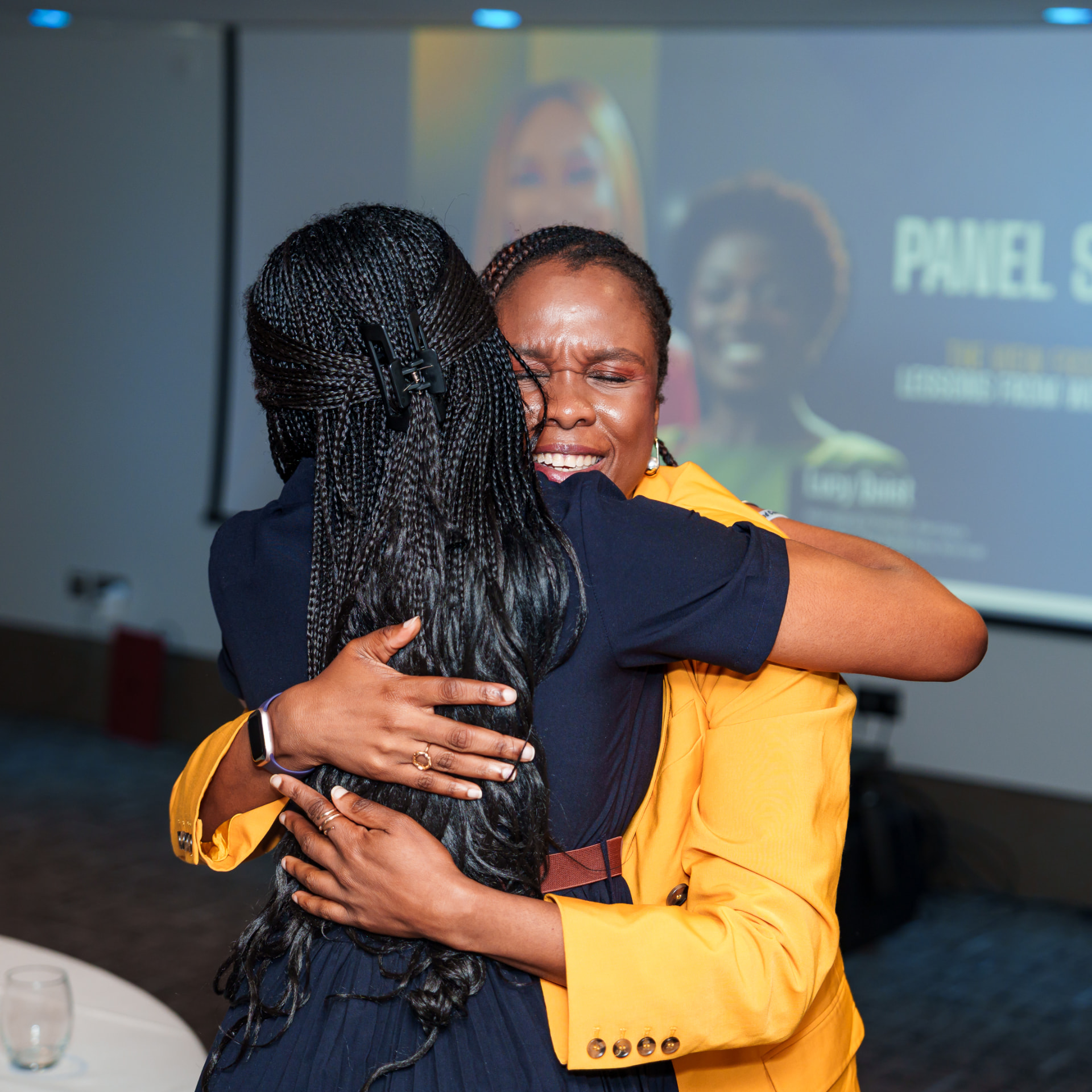 Two women embracing after a Christian in Corporate panel session